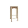Barkrakk Passage Counter Stool fra Audo Copenhagen i eik med messingfarget fotstøtte.