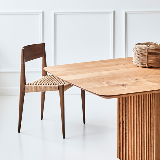 Spisebord Ten Table fra dk3 utstråler imponerende håndverk og kvalitet — dette kommer særlig godt fram i de vertikale sporene i bordets understell som er laget i massivt tre.