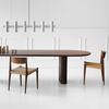 Spisebordet Plush Table fra dk3: Her hviler en oval bordplate på bordben som er satt sammen av en rekke med sylinderformer i tre, som skaper en vakkert bølget effekt på hver ende. Felles for alle spisebord fra dk3 er at designet understreker skjønnheten og de naturlige egenskapene til treet – og Plush Table er intet unntak.