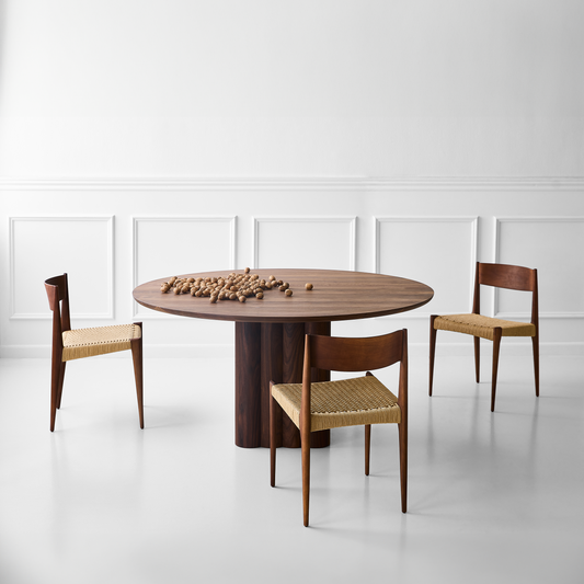 Rundt uttrekkbart spisebord Plush Table fra dk3: Her hviler en rund bordplate på et kubeformet bordben satt sammen av en rekke med sylinderformer i tre, som skaper en vakkert bølget effekt. Spisebordet kommer i forskjellige varianter, der du kan velge mellom fem ulike overflatebehandlinger og tre ulike størrelser, der du også kan velge mellom to høyder på bordet.