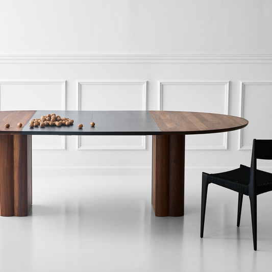 Spisebord Plush Table rundt fra dk3 kommer i ulike treslag og størrelser, og kan utvides med opptil fem ileggsplater i matchende materiale eller sort MDF. 