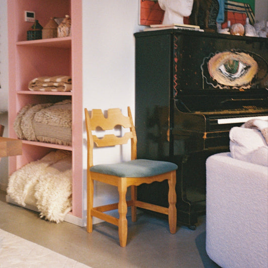 Spisestolen Razor Blade Dining Chair fra Dusty Deco er laget av massiv eik og har en karakteristisk silhuett, fremhevet av det intrikate, utskårne ryggpanelet.