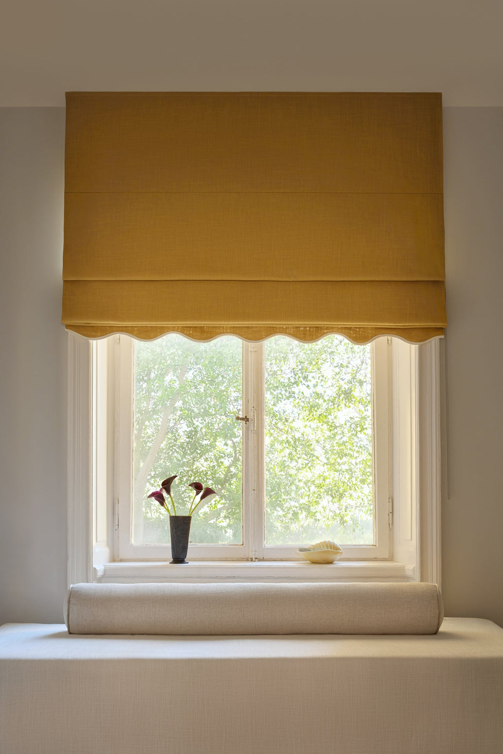 Sennepsgul mørkleggende liftgardin i vevd lin Scallop Edge fra Gotain i fargen Mustard / Ivory. Denne liftgardinen gir effektiv – og vakker – mørklegging på soverommet.
