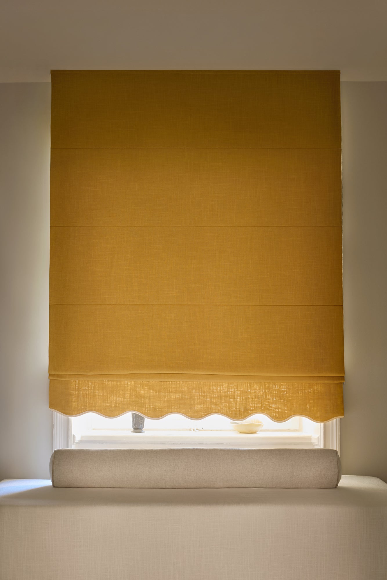 Sennepsgul mørkleggende liftgardin i vevd lin Scallop Edge fra Gotain i fargen Mustard / Ivory. Denne liftgardinen gir effektiv – og vakker – mørklegging på soverommet.