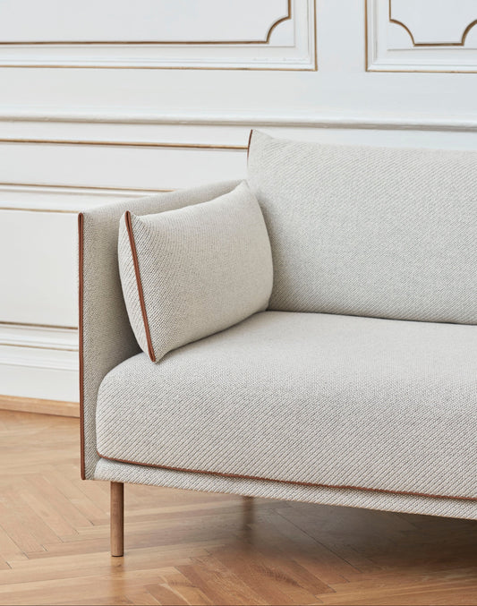 Her kan du bestille sofaen Silhouette som 2-seter eller 3-seter i det kremfargede tekstilet Coda 0100, med sømmer i konjakkfarget skinn. Du kan velge mellom sofaben i naturfarget eik, pilverlakkert svart metall eller krom.