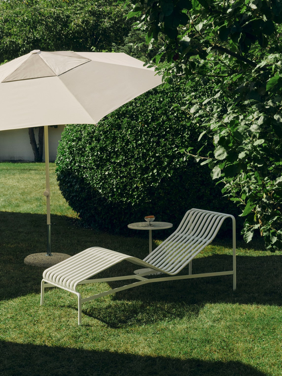 Parasollfoten til parasollene i Terrazza-serien fra Hay er laget i betong og galvanisert jern og veier 35 kg. Her med Off-White / lysegrå parasoll Terrazza Hexagon. Parasoll og parasollfot selges separat.
