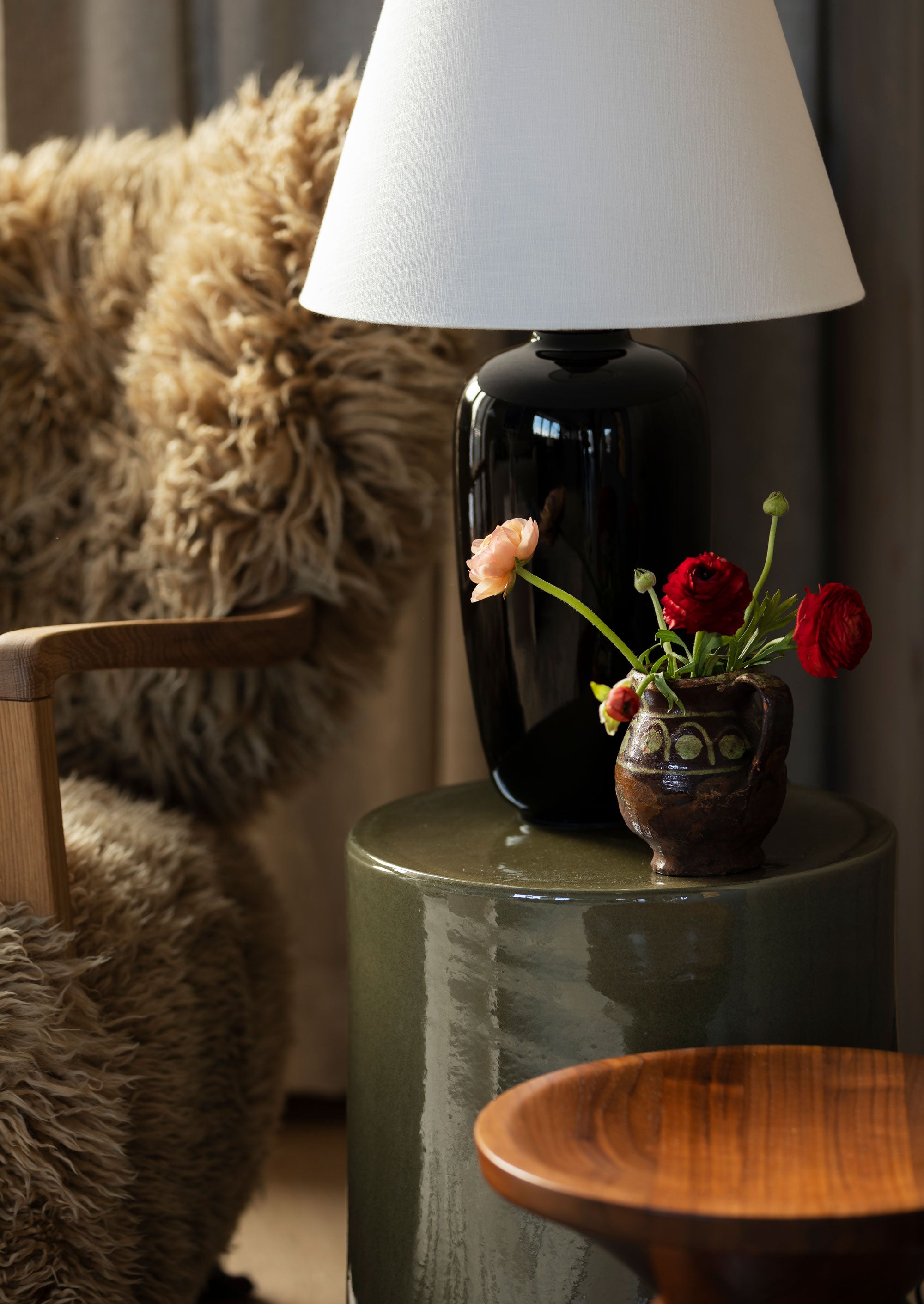 2. Hytte interiør inspirasjon: Sidebordet og lampen i glasert keramikk står i fin kontrast til lenestolen i saueull. Miks gjerne grove og polerte materialer og legg litt ekstra omtanke i detaljene.