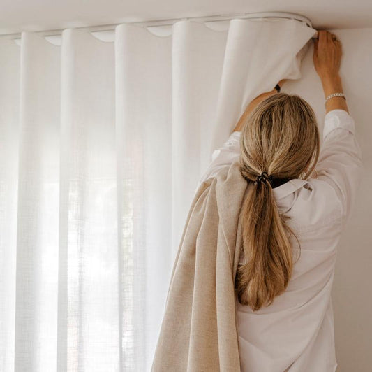 Lingardin Elegant med Wave oppheng i takskinne. Hvit gardin mot hvite vegger. 