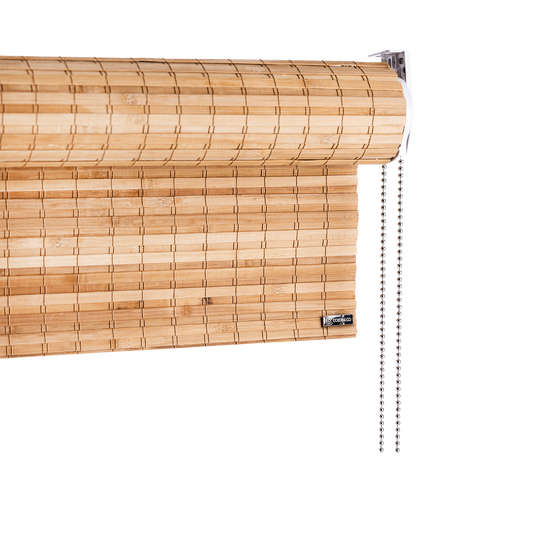 Rullegardin heldekkende bambus brun fra Color&Co med kjedetrekk: En elegant rullegardin i brun bambus, med ca. 0,9 cm brede overlappende bambuspinner vevet sammen med lys brun tråd, og varmebehandlet for å gi bambusen en fin brunfarge. Gardinen har ca. 90% lysskjerming, og gjør seg perfekt når du trenger en tettere solskjerming, for eksempel til tv-stuen eller soverommet.