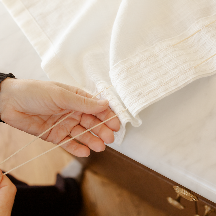 Ta tak i rynketråden i den ene enden og skyv stoffet jevnt bortover båndet. 