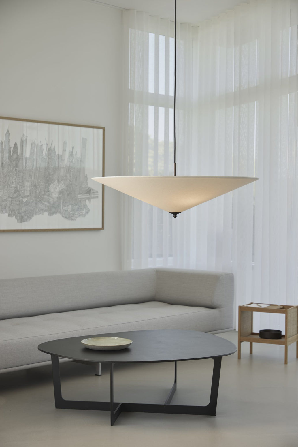 Futé 1000 Tipp er den største takpendelen i Lyfas Futé-serie, designet av det dansk-italienske studioet GamFratesi. Pendellampen har en rund, konveks skjerm i et kremfarget kanvastekstil med detaljer i brunert messing. Lampen måler 100 cm i bredden.