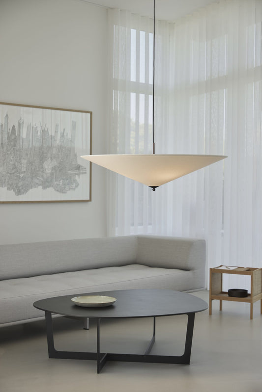 Futé 1000 Tipp er den største takpendelen i Lyfas Futé-serie, designet av det dansk-italienske studioet GamFratesi. Pendellampen har en rund, konveks skjerm i et kremfarget kanvastekstil med detaljer i brunert messing. Lampen måler 100 cm i bredden.