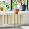 Designet er inspirert av 1960-tallets minimalistiske estetikk. Skjenken er gjennomfarget. Det vil si at både innside og utside har samme farge. På baksiden er det hull slik at du enkelt kan føre kabler gjennom om du vil bruke den som en lav TV-benk eller stereobenk.