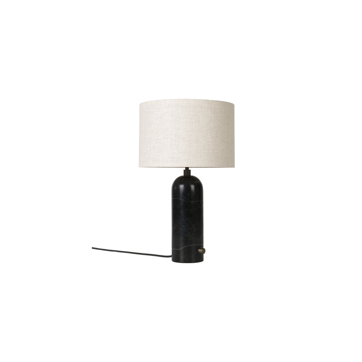 Den nye bordlampen Gravity er designet av Space Copenhagen for Gubi. Lampen har en tung sylinderformet base, og en lett og luftig skjerm som gir et mykt og vakkert lys.