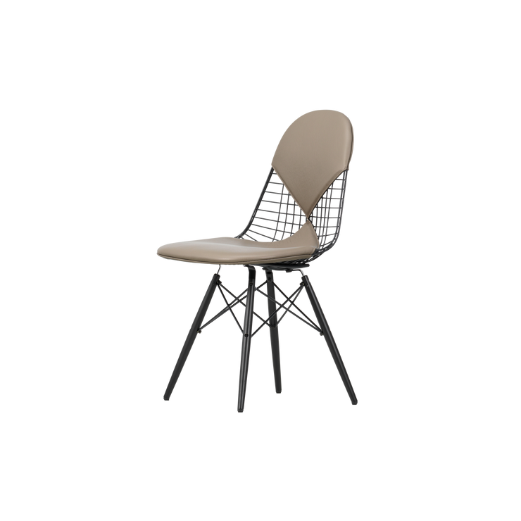 Stolen Wire Chair DKW med skinnpolstring i fargen Sand, er designet av Charles og Ray Eames for Vitra. Denne skulpturelle stolen skaper en nydelig kontrast i hjemmet ditt.
