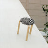 Den ikoniske krakken Stool 60, med karakterististk zebratekstil. Designet av Alvar Aalto.
