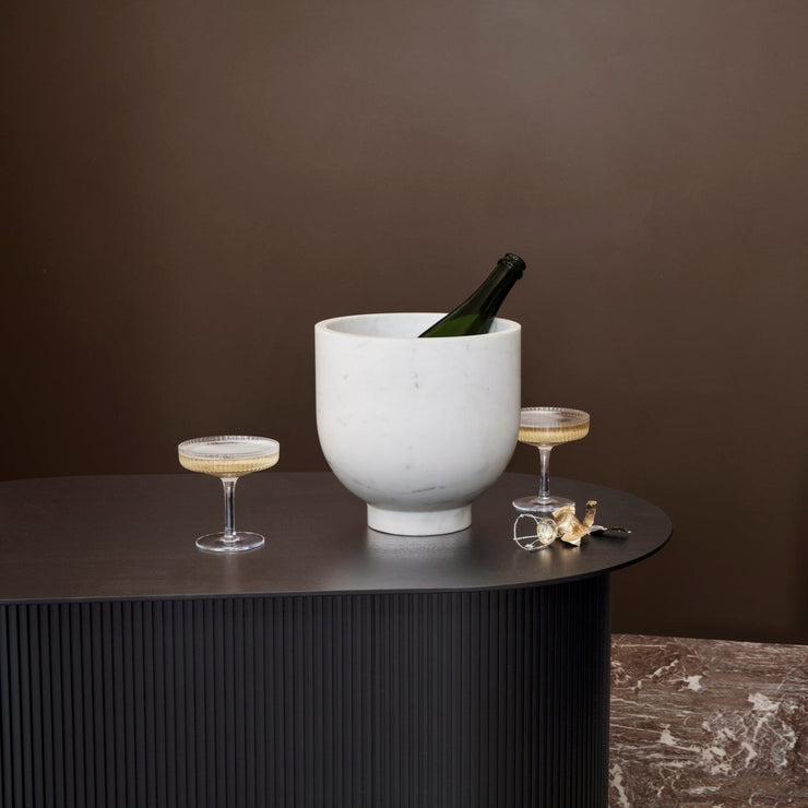 Formen er moderne, spennende og skuplturel og Alza champagne cooler er laget av naturlig, hvit banswara marmor som kan variere litt og gjør hvert produkt unikt.