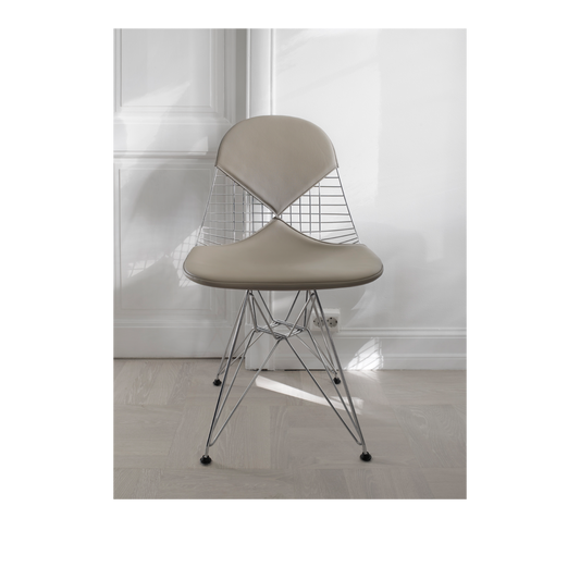 Wire Chair DKR i krom, er designet av Charles og Ray Eames for Vitra. Denne skulpturelle stolen har et polstret sete og rygg i det eksklusive skinnet leather premium.
