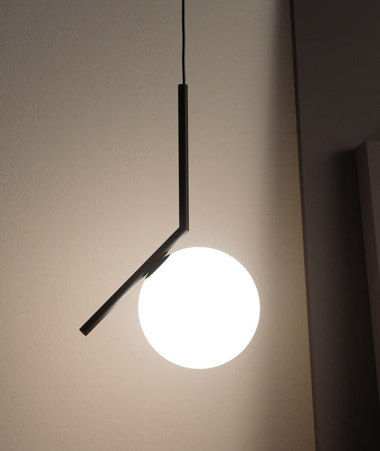 Takpendelen IC S2 i svart fra Flos, er en klassisk lampe med en moderne form. Glasskuppelen balanserer perfekt på kanten av en stang, som et stykke balansekunst – noe designeren Michael Anastassiades utforsker gjennom hele lampeserien IC