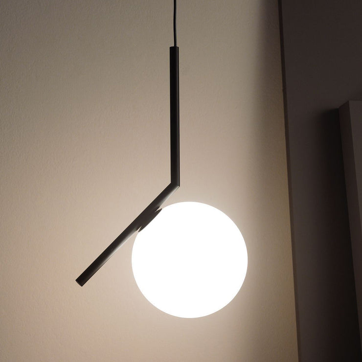 Takpendelen IC S2 i svart fra Flos, er en klassisk lampe med en moderne form. Glasskuppelen balanserer perfekt på kanten av en stang, som et stykke balansekunst – noe designeren Michael Anastassiades utforsker gjennom hele lampeserien IC