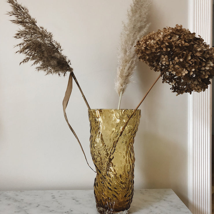 Ambisjonen til Hein Studio, var å skape en vakker og rolig vase som gjør omgivelsene litt finere hver eneste dag - både med og uten blomster. Vasen har en rå og spennende overflate kommer i flere farger.