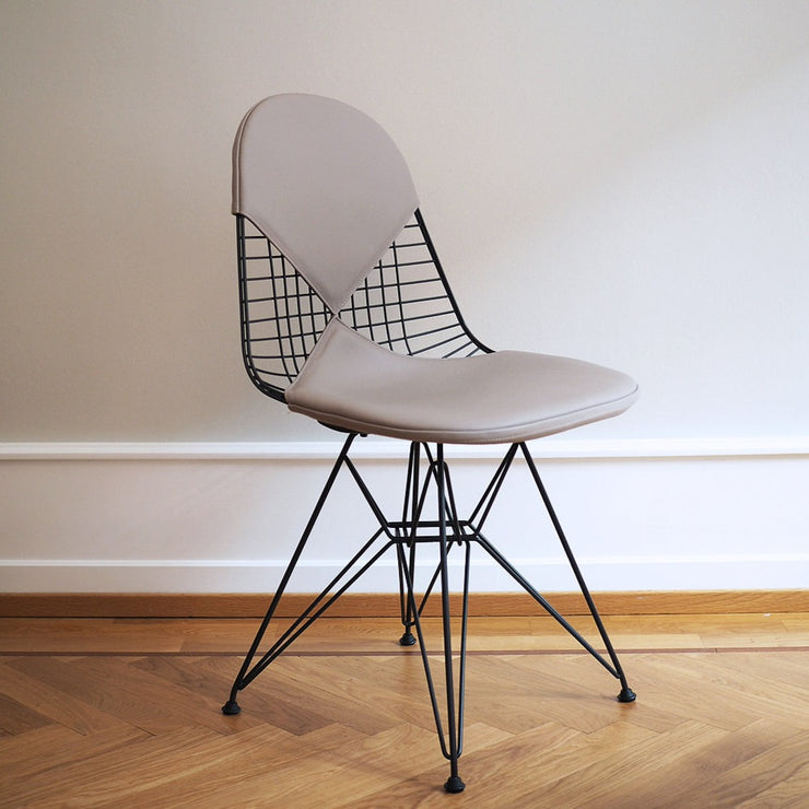 Wire Chair DKR, er designet av Charles og Ray Eames for Vitra. Denne skulpturelle stolen har et polstret sete og rygg i eksklusivt sandfarget skinn.