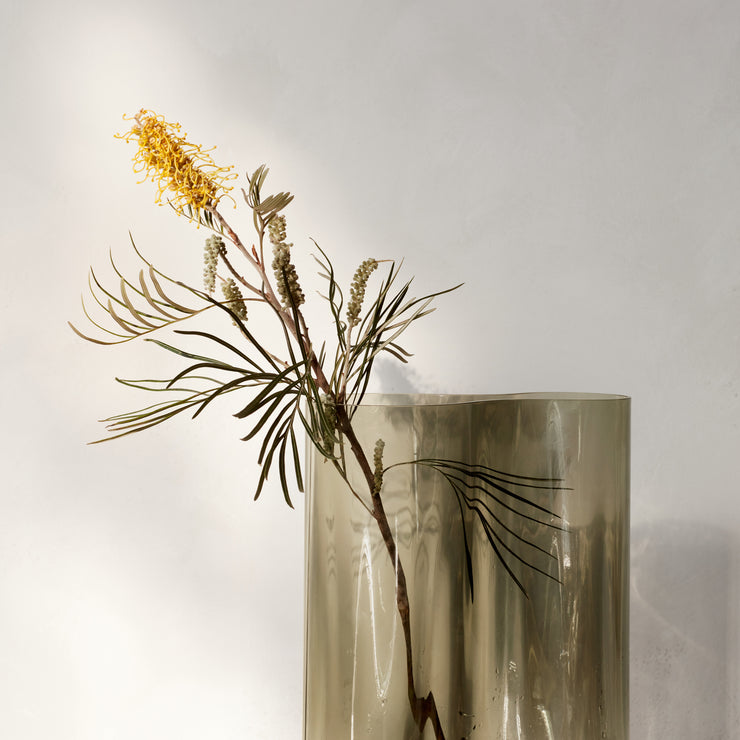 Vasen Aer har en elegant og myk form, og er laget i munnblåst, sotet glass.