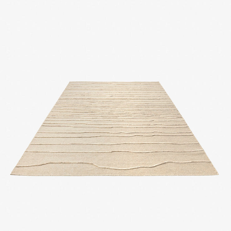 Teppet Sand, i ren, ufarget ull og med dekorativt relieffmønster. 