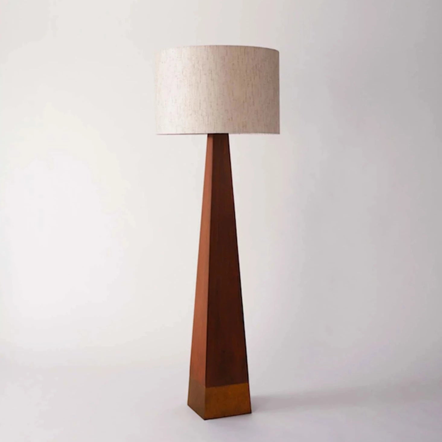 Gulvlampen Pyramid fra Dusty Deco i mørk mahogni er en høyreist, vintageinspirert lampe med en beige tekstilskjerm som gir et behagelig og mykt lys. Et garantert blikkfang i rommet!