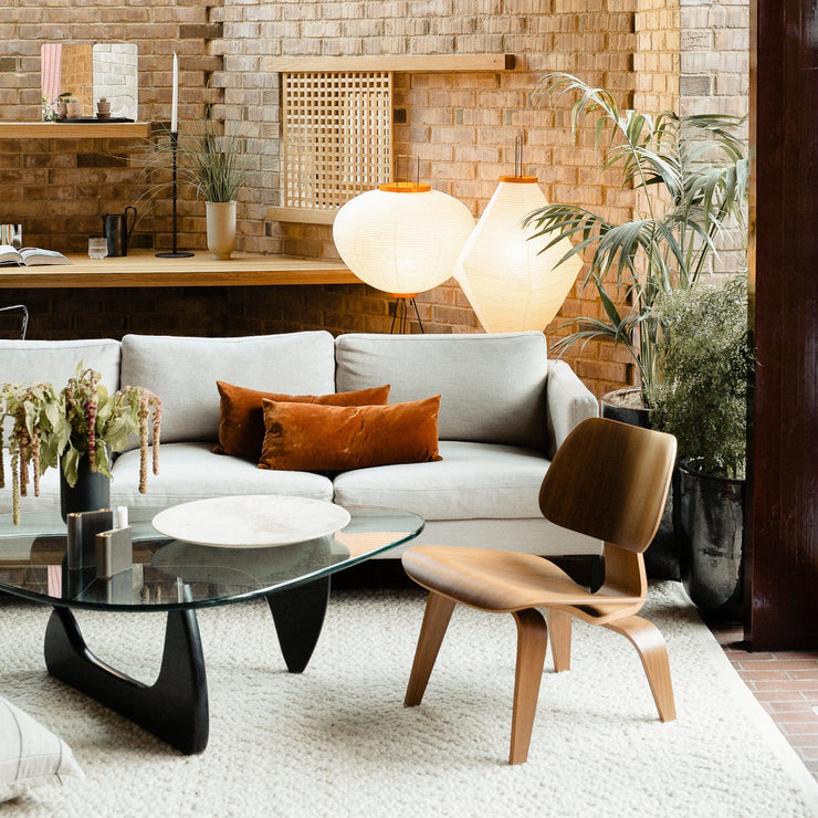 Eames Plywood LCM loungestol i ask fra Vitra er et nydelig møbel til stuen din. Akari-lampene i bakgrunnen er designet av Isamu Noguchi, som ville gjenskape det myke og vakre sollyset, ved å filtrere lyset fra lyspæren gjennom det det japanske papiret, som har en ujevn struktur og varm fargenyanse.