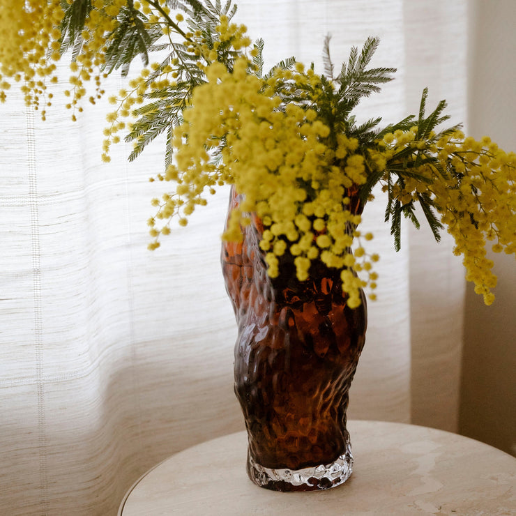 Perfekt vase til mimosa! Ostrea glassvase fra Hein Studio i dyp rustbarge kommer helt til sin rett med blomster i klare farger. 