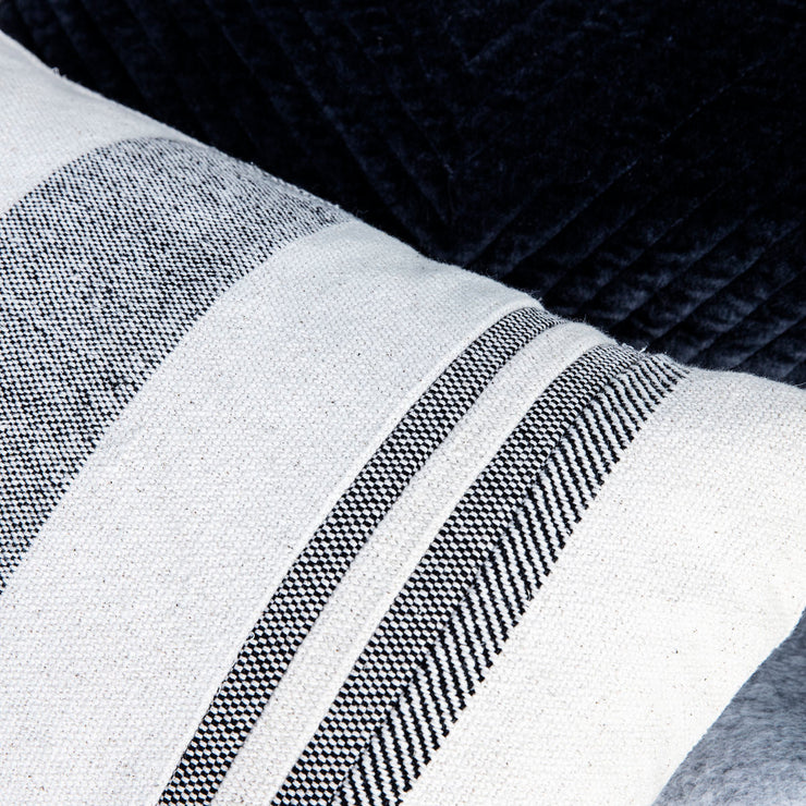 Tekstilet er i en frisk beige farge, med svarte striper i ulike bredder.
