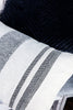 Tekstilet er i en frisk beige farge, med svarte striper i ulike bredder.